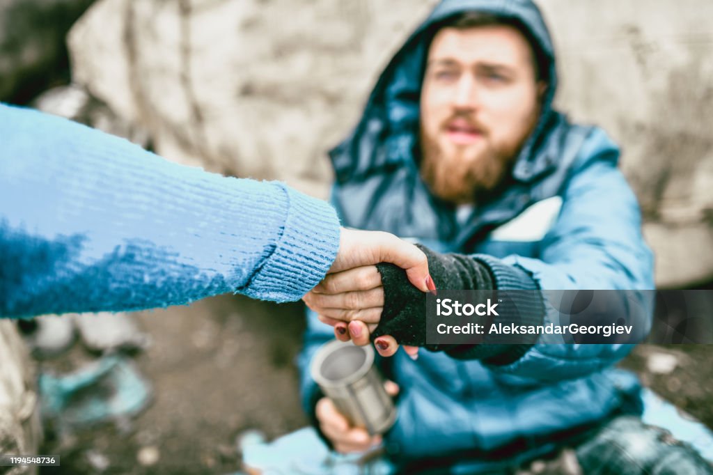 Homeless Male On The Street Getting Help From Female Homelessness Stock Photo