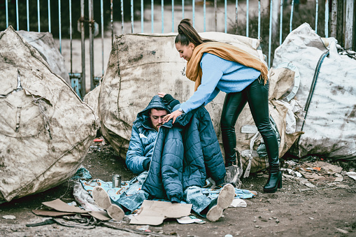 Female Trying To Warm Poor Homeless Male