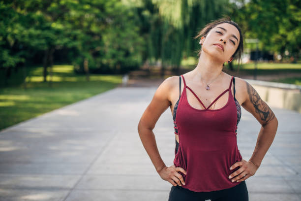 istock Beautiful young woman stretching in park. 1194550564