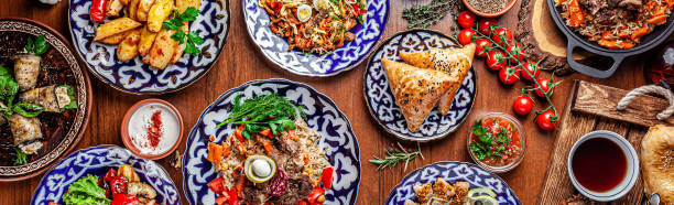 Traditional Uzbek oriental cuisine. Uzbek family table from different dishes for the New Year holiday. The background image is a top view. Traditional Uzbek oriental cuisine. Uzbek family table from different dishes for the New Year holiday. The background image is a top view. halal stock pictures, royalty-free photos & images
