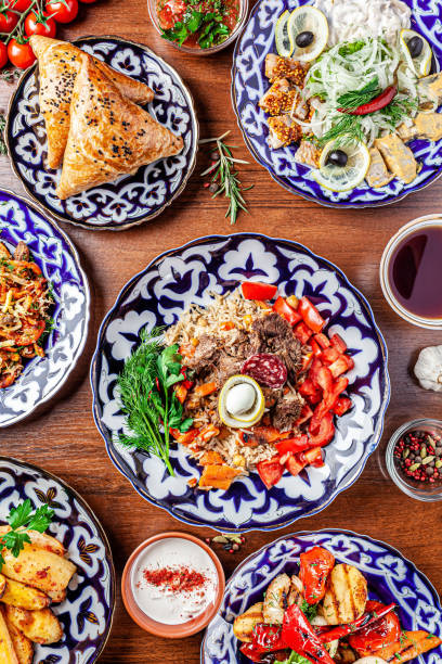 Traditional Uzbek oriental cuisine. Uzbek family table from different dishes for the New Year holiday. The background image is a top view. Traditional Uzbek oriental cuisine. Uzbek family table from different dishes for the New Year holiday. The background image is a top view. uzbekistan stock pictures, royalty-free photos & images