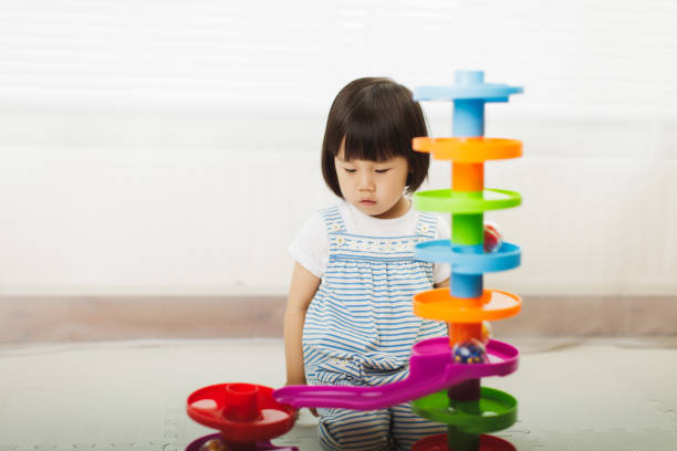 istock toddler girl play stack ball game at home 1194551403
