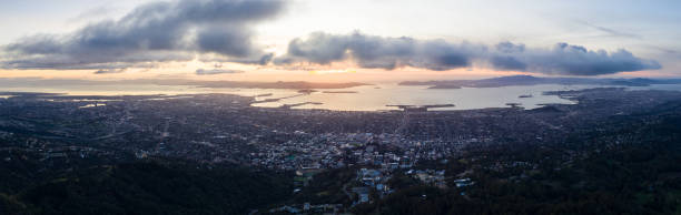 Aerial of Serene Sunset Over San Francisco Bay A serene sunset illuminates the San Francisco Bay area including Oakland, Berkeley, Emeryville, El Cerrito, and San Francisco in the distance. sea population stock pictures, royalty-free photos & images