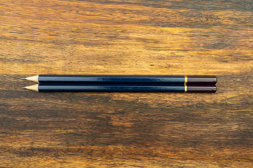 Three sharpened pencils on a school desk with a pencil sharpener and eraser