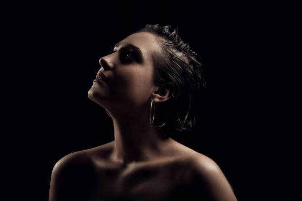 istock woman portrait, side view, black background. 1194552720