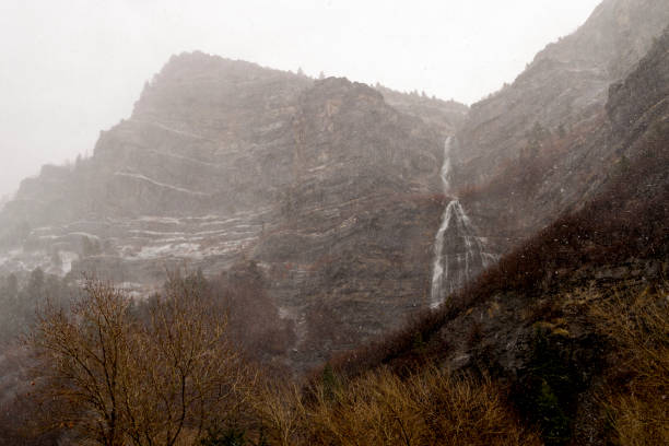 Waterfall Descending from a Mountain During a Snowstorm