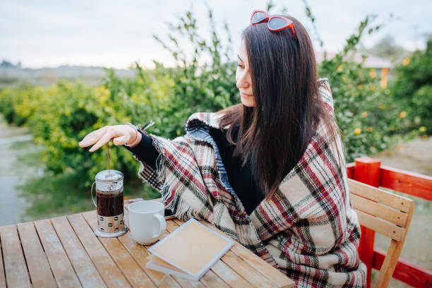 istock Woman drinking coffee and reading a book at the veranda 1194559417