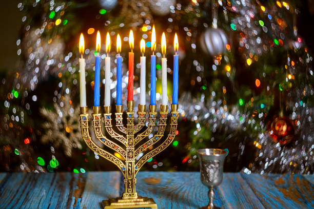 istock Hanukkah table with menorah and burning candles on sparkle background with defocused colored lights. 1194565564