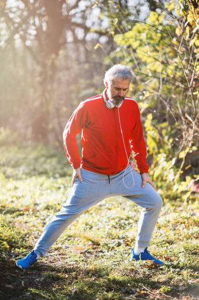 istock Senior man runner stretching outdoors 1194566734