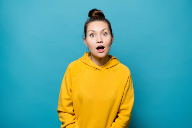 istock girl in a bright sweatshirt expressively surprised 1194573532