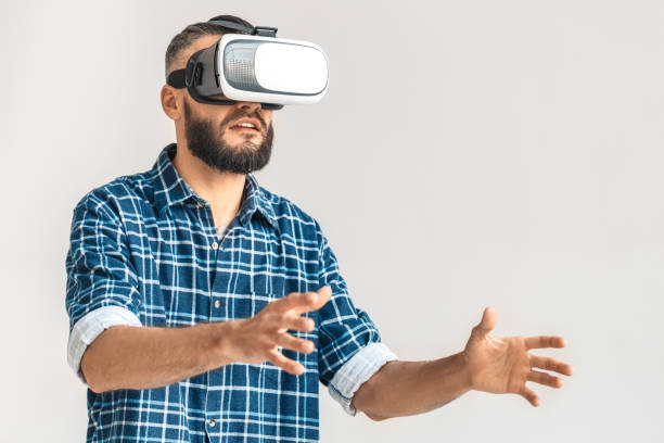 istock Freestyle. Guy wearing vr headset in checkered shirt standing isolated on white playing game excited 1194573688