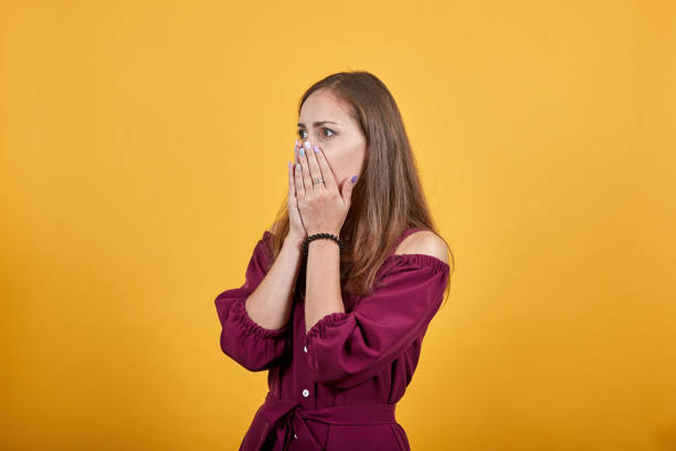 istock Young girl hides her mouth with her hands 1194575010