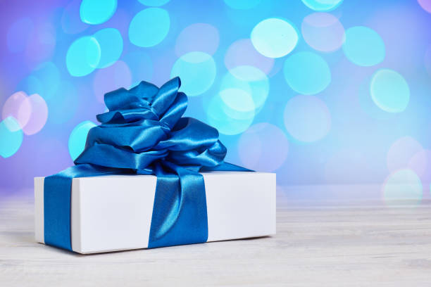 istock Gift box with a classic blue bow on a background with bokeh defocus background. 1194576371