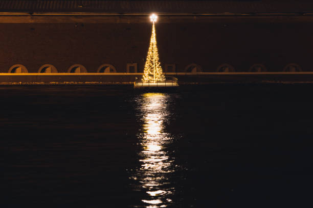 istock Christmas tree floating on the water with lights reflection 1194576419