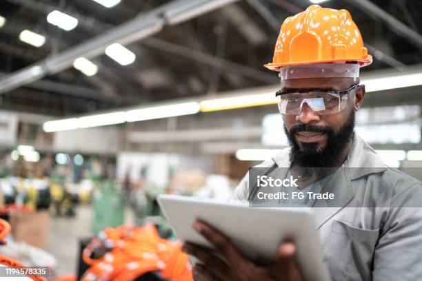 Man Working With His Digital Tablet In The Factory - Fotografias de stock e mais imagens de Fabricar - Fabricar, Fábrica, Felicidade