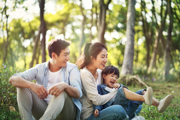 asian family with one child having fun in the woods young asian parents and son having fun outdoors in park family asian ethnicity couple child stock pictures, royalty-free photos & images