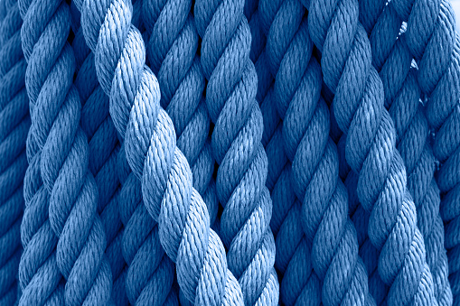 Trend color 2020 classic blue, top view, layout for design. Vintage skein of rope on a ship. Cable rope texture, layout for design. Material for scenery of interest. Ship props, marine subjects.
