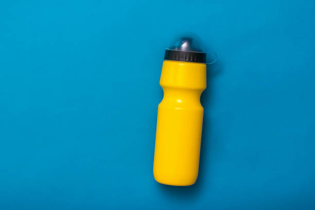 istock Yellow sports water bottle on blue background. 1194594689