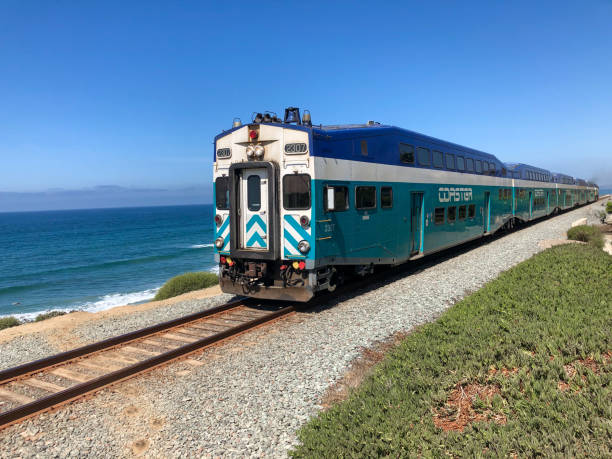 Amtrak Pacific Surfliner train with blue ocean and blue sky, passing by Del Mar, San Diego. USA.