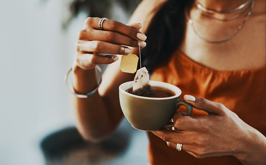 Cropped shot of a woman having a tea break at home