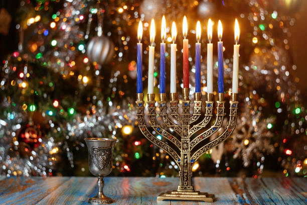 istock Hanukkah background with menorah and burning candles on sparkle background with defocused lights. 1194605653