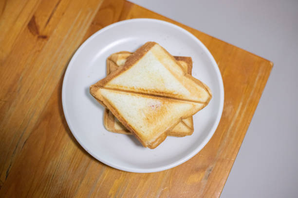 istock Toasted Bread Photos, On a white plate on a wooden table. 1194607175