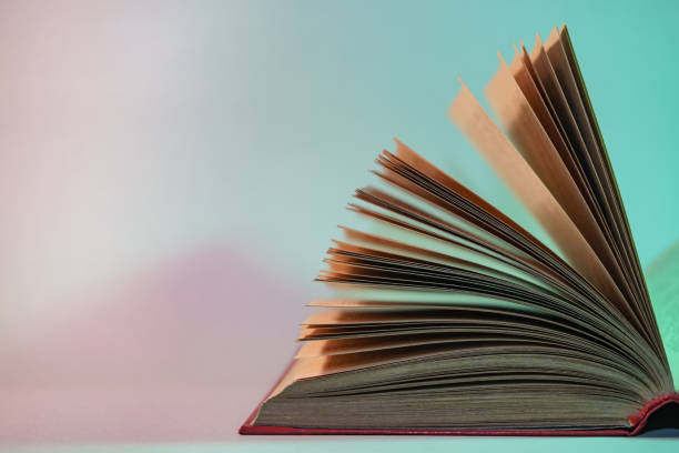 istock Beautiful open old book pages in neon  light. Minimalism retro style concept. 80s. Background pattern for design. 1194610532