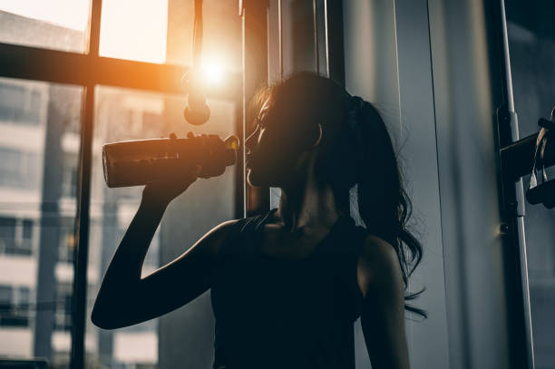 The sports young woman drinks protein in a shaker in a gym. Sports 
concept The sports young woman drinks protein in a shaker in a gym. Sports 
concept laboratory shaker stock pictures, royalty-free photos & images