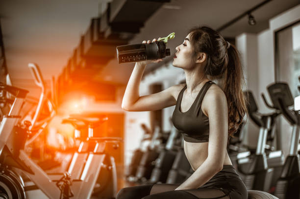 young fitness woman tired in gym drink   protein shake.exercising concept.fitness and healthy lifestyle - body building milk shake protein drink drink imagens e fotografias de stock