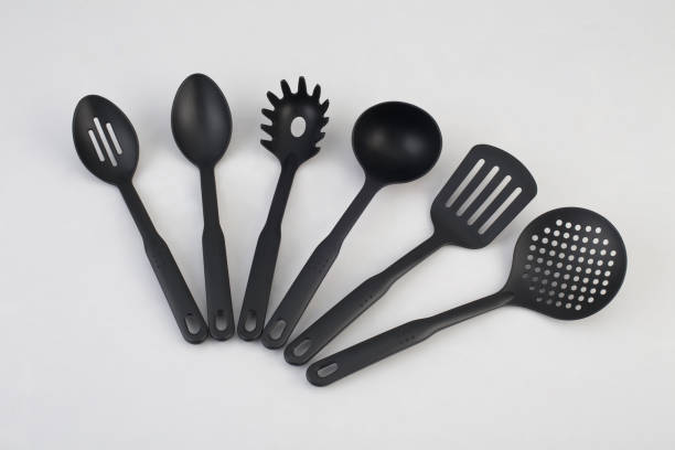 group of black plastic kitchen utensils isolated on white
