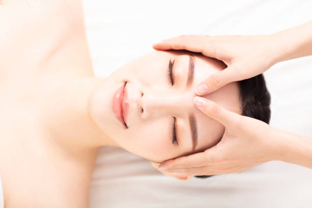 istock closed young woman face and head massage in spa 1194611849