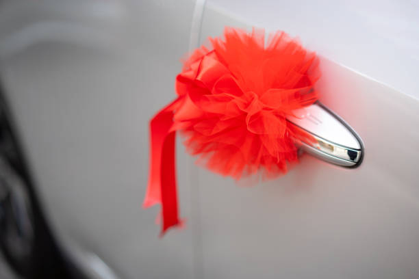 istock Red ribbon decoration on wedding car 1194617648