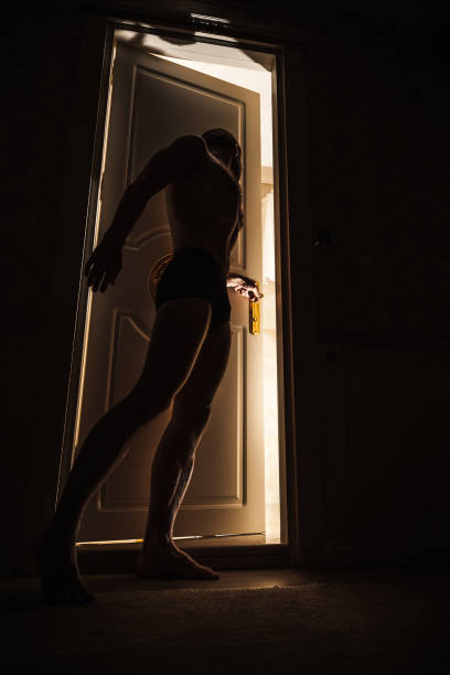 istock Young man peeps through the ajar door to a bathroom 1194618501