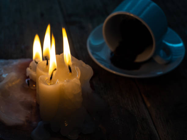 Divination on coffee grounds and a burning candle on an old wooden table.