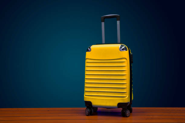 istock Yellow color traveling suitcase on dark background with copy space 1194622018