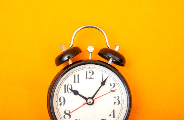 istock Vintage style alarm clock on yellow background banner with copy space 1194622103