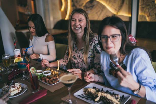 istock Female friends eating at restaurant 1194625643