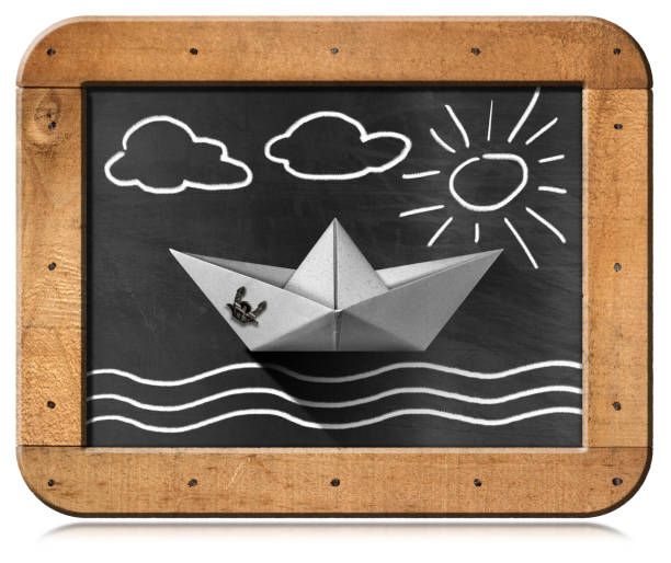 barco de papel flotando en el mar - blackboard con ilustración de tiza - nautical vessel isolated toy boat wood fotografías e imágenes de stock