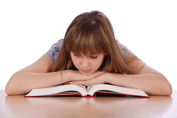 istock Girl sits at a table and reads the book 119462614