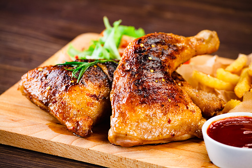 Fried chicken leg with fried potatoes and vegetables