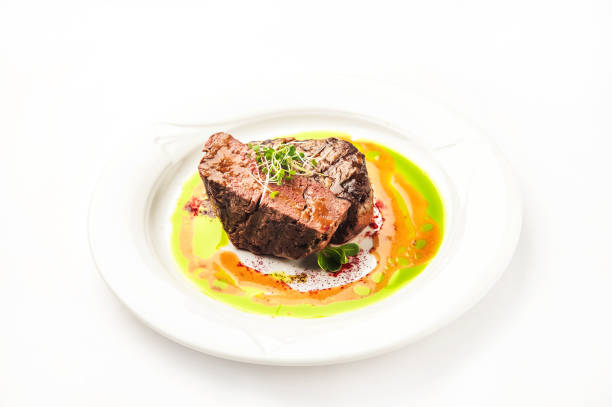 Tornedo in a restaurant close-up. Beef tenderloin steak with microgreens on a white plate and copy space.