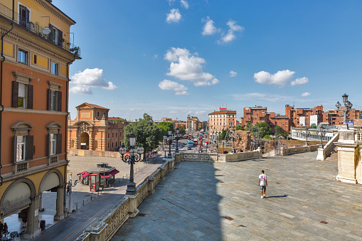 BOLOGNA, ITALY - JULY 10, 2019: People walk along 20th September square in the city historic center with Pincio Staircase, Galliera gate and fortress ruins.