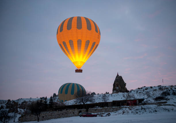 Hot air balloons flying over Cappadocia Hot air balloons flying over Cappadocia cappadocia winter photos stock pictures, royalty-free photos & images
