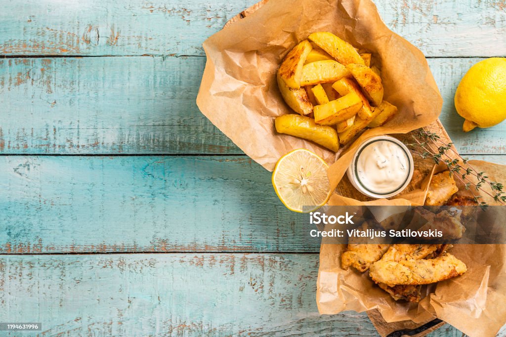 Fish and chips on blue wooden table, British traditional food. Fish and Chips Stock Photo