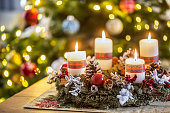 Advent wreath with four white burning candles christmas ball and decorations on a wooden background with festive atmosphere