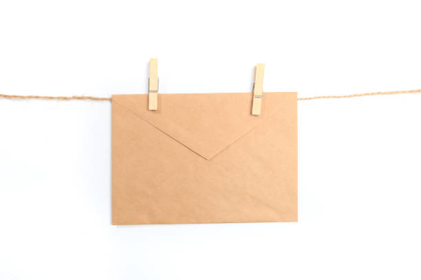 istock Old paper envelope hanging on rope on white background 1194635507