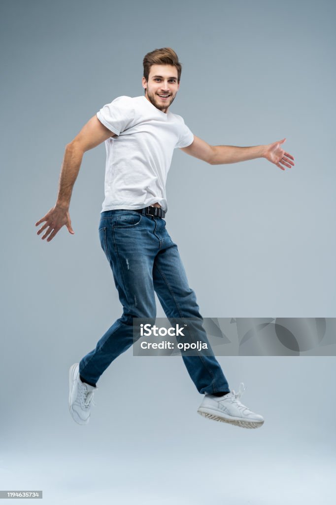 Fulllength Photo Of Funny Man In Casual Tshirt Blazer And Jeans Running Or  Jumping In Air Isolated Over Gray Background Stock Photo - Download Image  Now - iStock
