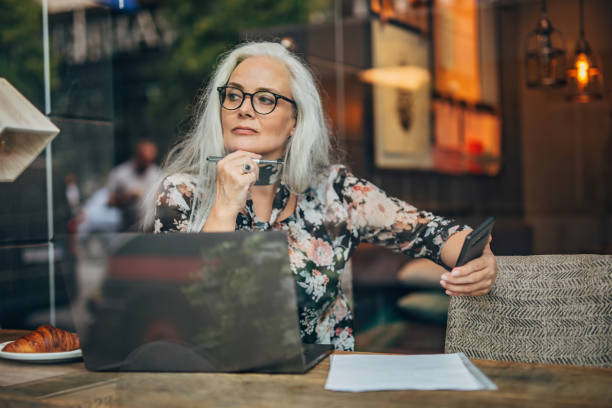 istock Mature lady author sitting in cafe alone 1194639153