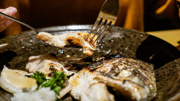Close Up, Eating Grilled Salmon Using Spoon Head Stock Photo