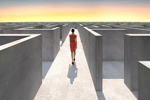 Businesswoman walks inside of a complex maze and looks for the way out, Digitally Generated Image.